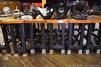 Four bar tables in a row showing black steel leg bases and natural wood tops among other equipment.