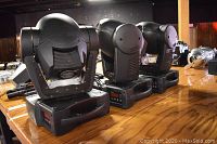 Three Martin Mac 250 moving head lights arranged on a wooden surface
