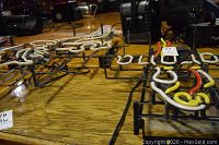 Top view of two neon signs on wooden table showing white, red and yellow tubing and black metal frames