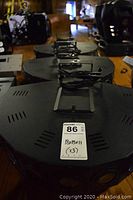 Top-down view showing three identical circular stage light units on table with power cables and mounting brackets visible