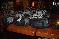Row of black/gray stage light fixtures laid out on a wooden table
