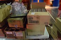 Overhead view of stacked plastic pitchers on tray and open cardboard cases of beer glasses