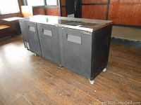 Angled front view showing three doors and stainless steel top