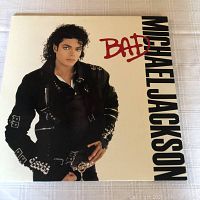 Front cover of Michael Jackson Bad vinyl album showing Michael Jackson in black outfit with 'BAD' in red and large vertical 'MICHAEL JACKSON' text.