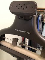 Close-up image of the Rowenta clothes steamer with metal hanger and steam nozzle showing the Rowenta logo clearly.