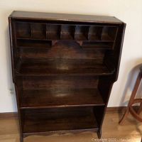 Front view of vintage oak bookcase showing top compartments and shelves.
