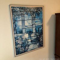 Front view of framed wall art showing gray and blue print with columns and flowers