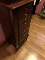 Front and side view of tall slender furniture piece showing cherry finish and front drawers