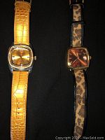 Two Joan Rivers fashion watches side by side showcasing different strap patterns and dial colors on black background.