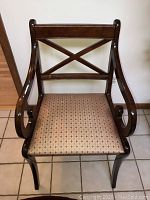 Front view of cherry finish accent chair showing the crossed backrest and patterned seat upholstery.