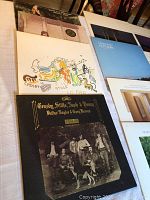 Multiple vinyl albums laid out on a table including Crosby Stills Nash & Young, Graham Nash, Jackson Browne albums.