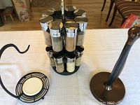 Photo showing spice rack carousel with labeled glass jars holding spices with metal lids.