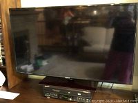 Samsung 50-inch plasma TV powered off, mounted on or sitting above AV receiver.