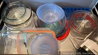 Several ovenproof bowls including Pyrex glass bowls stacked and arranged in various sizes and shapes including round and square