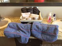Overview of towels in basket with two blue bath towels on counter
