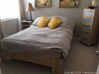 Full view of assembled bed frame with mattress, bedding and decorative pillows