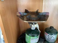 Photo of one burner propane stove mounted on propane canister showing stove top and control knob