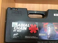 Black plastic case for radial snow chains by SCC with label and price tag