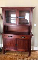 Front view of closed hutch showing overall condition, upper glass doors, drawer and lower cabinet