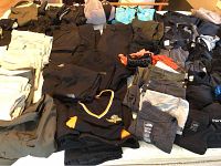 Full spread of assorted folded pants, shorts, jackets and tops on table