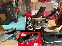 Overall grouping of eleven boxed pairs: boots, sneakers, pumps, slip-ons, clogs