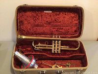 Trumpet and accessories arranged inside open hard case