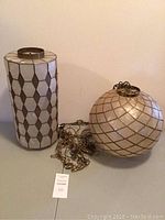 Both spherical and cylindrical Capiz hanging light fixtures on table showing shapes, chains, and general condition