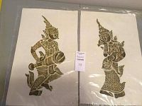 Two vintage Thai rubbings laid side by side, showing full figure details and embossed patterning.