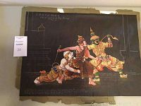 Full view of the painting showing three elaborately dressed figures in traditional Thai costume, seated and interacting in a narrative scene on a dark background.