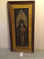 Full view of framed bas-relief temple rubbing artwork against wall, showing frame and overall size.