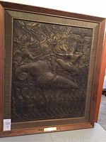 Frontal view of the framed bas-relief rubbing showing the entire artwork and frame, including the brass plate.