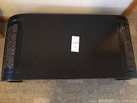 Top view of the black lacquer wood table showing its rectangular shape and the carved wooden accents at both ends.