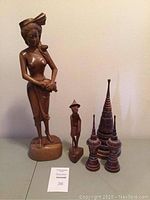 All five carved wooden figures and sculptures displayed together showing relative size and detail.