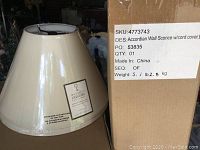 Ivory lamp shade next to cardboard box labelled SKU 4773743