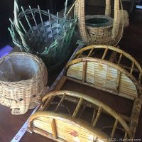 Three wicker plant baskets arranged on a surface with two bamboo-framed rattan shelves beneath.