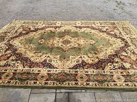 Full view of the rug laid flat outdoors on pavement