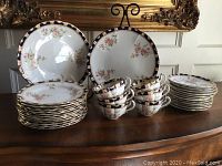 Full set arranged on tabletop showing cups, saucers, plates and platters