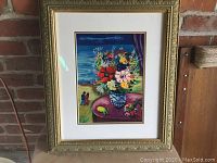 Framed serigraph print depicting floral arrangement by the sea