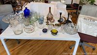 Wide shot of the table showing all assorted glassware, candleholders, and decorative items