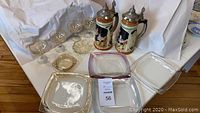 Full lot overview with beer steins, clear glasses, ashtrays, and snacks plates arranged on a table