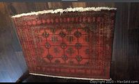 Full top view of red Persian hand knotted rug with geometric floral motifs