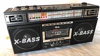 Front view of WFX boom box showing speakers, cassette window with auto stop, and tuning scale.