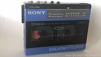 Front view of a Sony Walkman portable cassette player model WM-F15 showing cassette window and frequency dial.