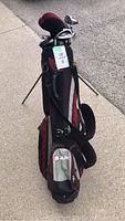 Full image of Ram golf bag standing upright on concrete with clubs inside, tag labeled 6 attached