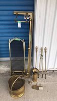 Photo showing all brass fireplace equipment including screen, tools, bucket, and log holder.