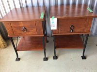 Two wooden end tables side by side with metal legs, showing surface wear and scratches on tops