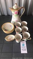 Full set of Nippon teapot, cups, saucers, and small dishes on display with auction tag
