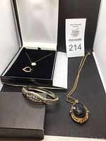 Lot contents displayed including black cameo locket necklace, heart necklace with pearl accents, and rhinestone bracelet