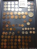Top view showing all arranged coins including pennies, nickels, quarters, and a large commemorative coin on a black background.