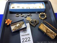 Top down view showing full assortment of jewelry with stud earrings, hoop earrings, brooches, pendants, bracelet, and hat pins.